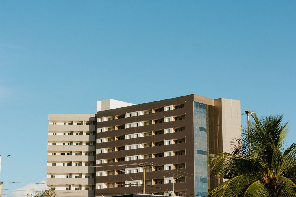 Palmas é selecionada em edital nacional e poderá receber até R$ 2 milhões para arborização urbana Edifício residencial em Palmas, no Tocantins, cercado por palmeiras sob céu azul